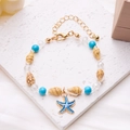 Detail of beaded shell bracelet featuring blue starfish charm and golden lobster clasp - Starfish Conch Beaded Bracelet (Blue)