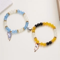 Dettaglio dei bracciali con gatto e cuore magnetico realizzati con perle di vetro colorate - Blu e Giallo