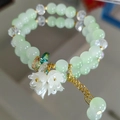 Light green beaded bracelet featuring white lily of the valley flower charms and crystals - Green Lily