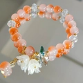 Orange cat-eye beaded bracelet with white lily of the valley flower charms and gold spacers - Orange Lily