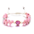 Detalle de pulsera tejida a mano con cuentas rosas y colgante morado brillante - Rosa