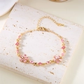 Detaillierte Nahaufnahme der rosa Kristallblumen auf dem verstellbaren Goldarmband - Rosa Armband