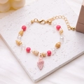 Bohemian shell and conch bead bracelet in pink with golden accents on a stone tray - Conch Beaded Bracelet (Pink)
