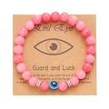 Pink beaded 8mm bracelet with a blue Evil Eye glass charm on a kraft display card - Pink Glass Beads (BR24Y0308-2)
