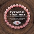 Makroaufnahme von 8mm rosa Erdbeerquarz-Perlenarmband auf natürlichem Holzgrund - Imitations-Erdbeerquarz