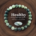 Makroansicht von 8mm grünen Natursteinperlen-Armband auf rustikalem Holzhintergrund - Grüner Strohhutstein