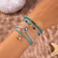 Detail of bohemian multilayered beaded bracelets with pineapple and evil eye charms - Style 1