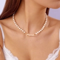 Détail du collier de perles élégant avec pendentif MAMA doré porté au cou - Collier de perles / Or