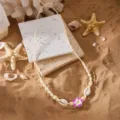 Handgefertigte gewebte Halskette mit Muscheln und einem lila Blumenanhänger - Lila