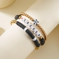 Detailopname van driedelige voetbalarmbandset met polymeerklei kralen en bedeltjes - Voetbal