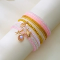 Detail of layered beaded bracelets with pink beads and golden sea animal charms - Style 29