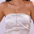 Dettaglio della collana lunga a Y dorata con perle su modella in raso bianco - Perla Artificiale Oro