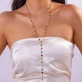 Dettaglio di un'elegante collana a Y con cristalli colorati su una modella - Oro Strass Tondo Colorato Nappina