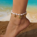 Close-up of pearl anklet with gold starfish and shell charms worn on a summer beach - Multiple Ocean Charms Style (AK25Y0045)