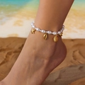 Close-up of pearl anklet with gold starfish and shell charms on a sunny beach - Anklet