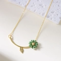 Halsketting met groene madeliefjeshanger en goudkleurig blad aan fijne ketting - Ketting Groen