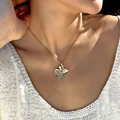 Gros plan du collier fleur dorée avec pétales texturés sur le cou d'un mannequin féminin - Collier Fleur en Métal