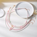 Detail einer mehrlagigen Erdbeer-Perlenkette mit Schmetterlingen und goldenem Herzanhänger - 4-Lagen-Halsketten-Bündel / Rosa Erdbeere (Stil 2)