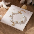 Böhmisches Muschel-Seestern-Armband mit weißen Dekosteinen und Goldanhänger für den Strand - Armband-Weiß