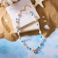 Blaue Ozean-Halskette mit natürlicher Muschel und Perlenanhänger auf Strand-Hintergrund - Blau Perle Muschel Halskette