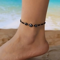 Bohemian evil eye beaded anklet with black and gold beads on a sunny beach background - Triple Evil Eye Style (AK25Y0048)
