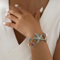 Gouden Hawaïaanse oceaanarmband met blauwe zeester, schelphangers en kleurrijke kristallen - Blauwe Zeester Armband