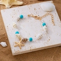Blaues Muschelarmband mit Seesternanhänger und Türkisperlen für den Strandurlaub - Blaues Seestern-Armband