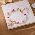 Goldenes Ozean-Armband mit rosa Marmorperlen, Natürmuscheln und einem Seestern-Anhänger - Rosa Seestern Armband