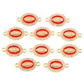 Détail macro de pendentifs ovales Vierge Marie en alliage doré avec émail rouge et strass - Rouge