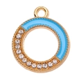 Makroaufnahme von goldenem Kreisanhänger mit hellblauem Emaille und glitzernden Strass - Blau