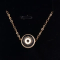 Macro shot of gold evil eye pendant with black and white enamel detail on velvet - Black