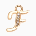 Détail d'un pendentif lettre F doré orné de strass brillants et d'un anneau de suspension - Lettre F