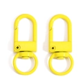 Detail of two bright yellow swivel lobster clasps with polished metal finish - Yellow