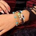 Detail von Halloween-Armbändern mit Totenkopf-, Kürbis-, Geist-Anhängern und BOO-Lettern - 5er Set / Blau