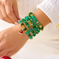Détail d'un ensemble de bracelets de Noël en perles vertes avec clochette rouge au poignet - Vert Forêt (BR25Y0526-3)
