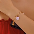 Bracciale natalizio dorato con ciondoli Babbo Natale e stelle indossato al polso - Bracciale Babbo Natale