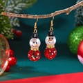 Detailed view of snowman earrings with rhinestones hanging on a festive pine branch - Full Rhinestone Red Snowman