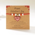Detail van rode gevlochten touwarmband met hartbedeltje op een Valentijns-displaykaart - Rood Hart Love Stijl (BR25Y0704-1)
