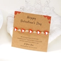 Dettaglio del bracciale con perline a cuore su carta kraft per regalo di San Valentino - Stile Cuore Rosso (BR25Y0746-3)