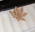 Macro view of golden maple leaf brooch with sparkling pavé crystals in a jewelry box - Gold Metal Pave Rhinestone Maple Leaf Style (BC23Y0223)