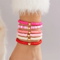 Nahaufnahme von bunten Heishi-Perlenarmbändern mit goldenen Herzanhängern - 6-teiliges Böhmisches Herzanhänger Stil (BR25Y0733-3)