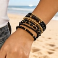 Bohemian black and gold beaded elastic bracelet set on a model with beach background - Style 4 / 7-Pack Set