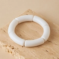 Close-up van matte crème acryl gebogen buisarmband op een decoratieve stenen basis - Melkwit Mat (AB0078-5)