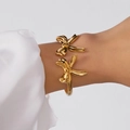 Eleganter goldener Armreif mit Schmetterlingsschleife und polierter Oberfläche für Damen - Spiegelpolierter Doppelschleifenstil (BR25Y0725-3)