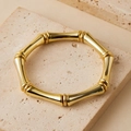 Boheemse gouden bamboe schakelarmband op een beige getextureerde natuursteen - Achtkantige Gouden Bamboe (AB0081-12)