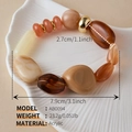 Macro detail of multicolored acrylic beads bracelet with golden spacers on a shell tray - AB0094-6