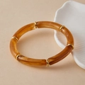 Macro-opname van Boheemse harsarmband met amberkleurige textuur en gouden ringen - Licht Barnsteen (AB0091-12)