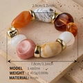 Detailed macro view of colorful acrylic beads and golden metal rings on a stone surface - AB0094-11