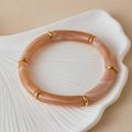Detail van een boho stretcharmband met gemarmerde perzikkleurige buisjes en gouden ringen - Roze Oranje Marmer (AB0091-11)