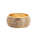 Dettaglio macro di un bracciale rigido dorato vintage con incisioni floreali e geometriche - Oro